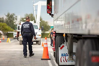 CBP officer inspecting a truck at a port of entry